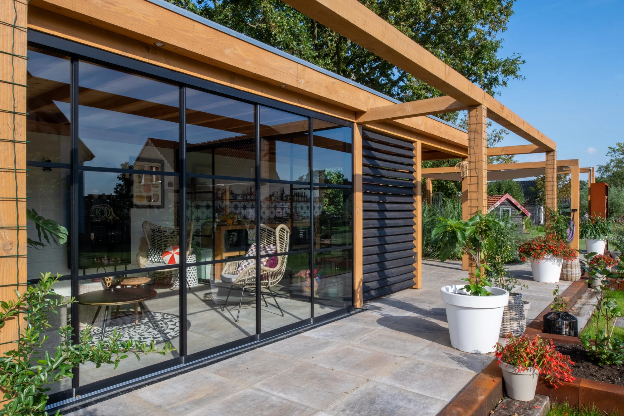 Eigen project in Waarland: glazen schuifwand onder een houten overkapping